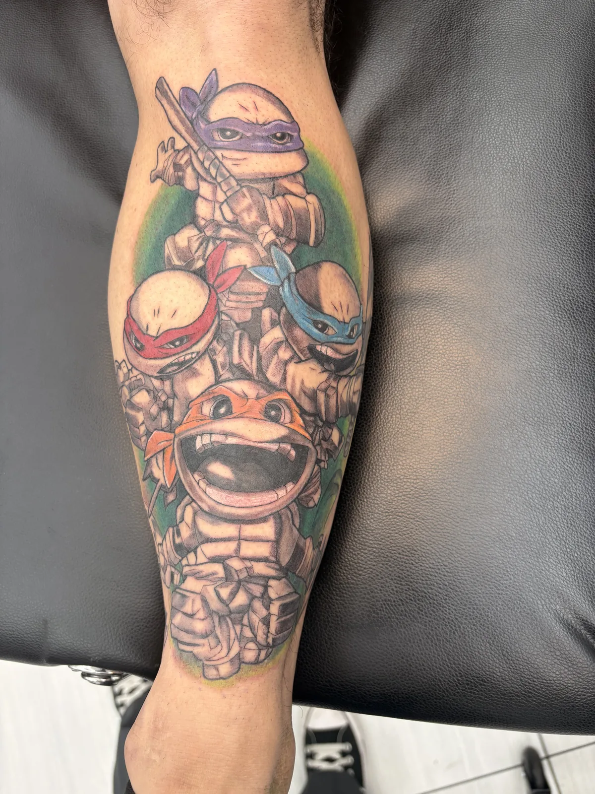 Color tattoo by Heather Baldwin — four chibi-style Teenage Mutant Ninja Turtles wrapped on the calf