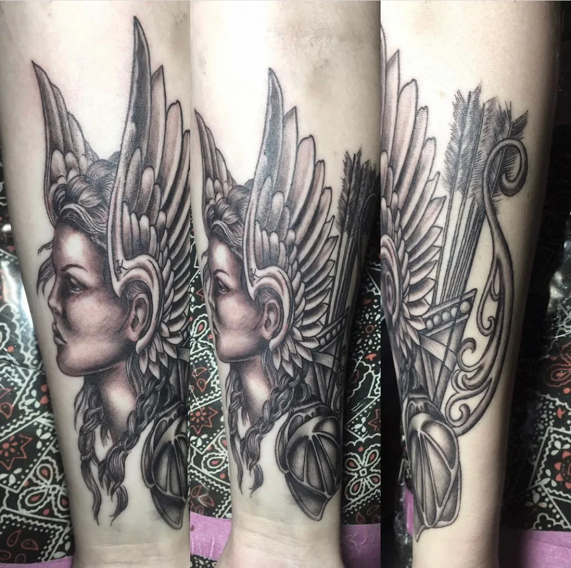 Neo-traditional tattoo by Heather Baldwin — winged Valkyrie warrior with quiver of arrows and bow, shown across three rotations on the forearm