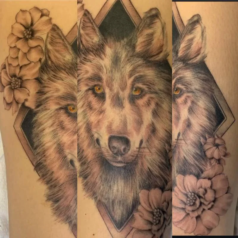 Heather Baldwin realism wolf tattoo surrounded by flowers on upper arm, Hawaii